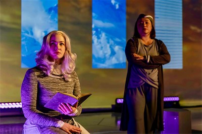 Rachel Rhea Shannon as Vashti and Lya Yanne as Flight Attendant